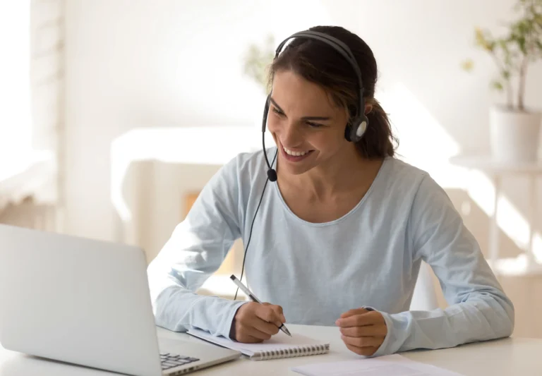 Professional woman with headset taking notes at a laptop—productivity outsourcing for Arizona businesses.