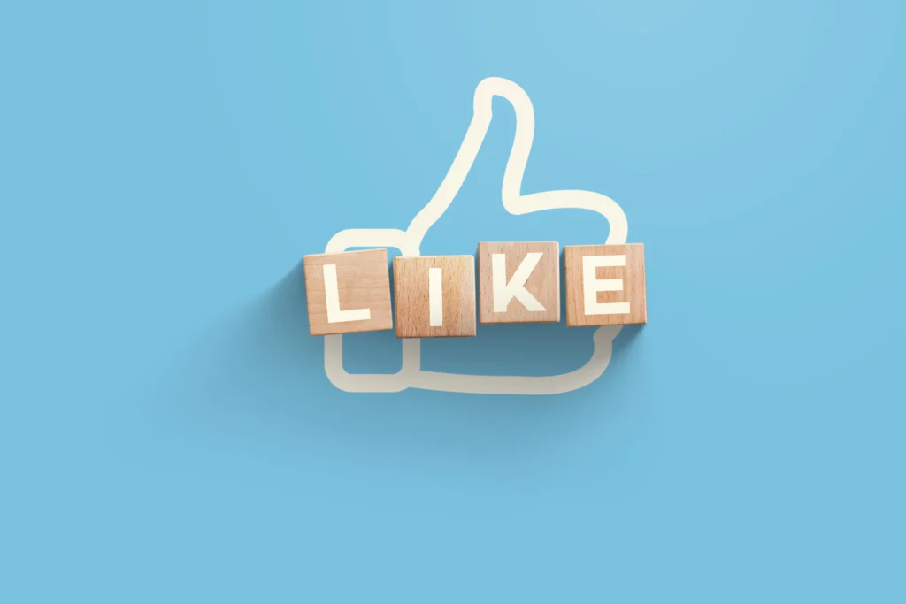 Like symbol made of wooden cubes showing the importance of consistent social media management for engagement.