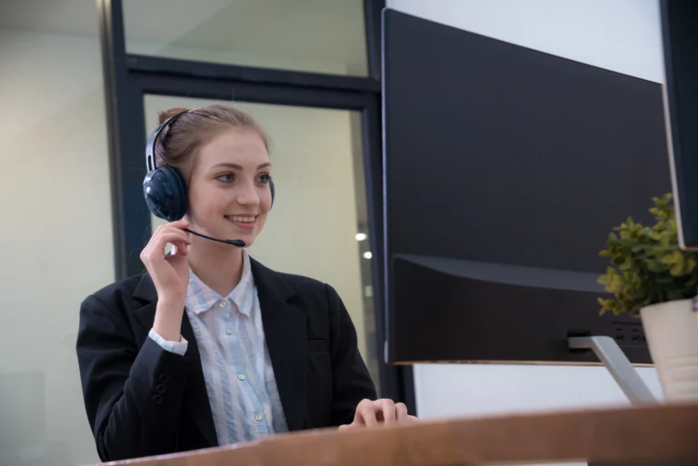 Business Assistant providing customer support at a desktop computer in a modern office
